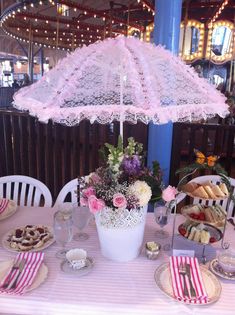 a table set up with plates, silverware and an umbrella