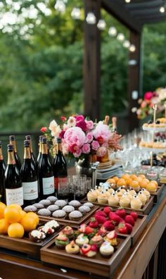 a table topped with lots of bottles of wine next to cakes and desserts on top of it