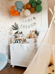 a teepee tent and some balloons in a room