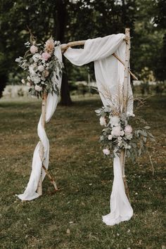 a wedding arch decorated with flowers and greenery