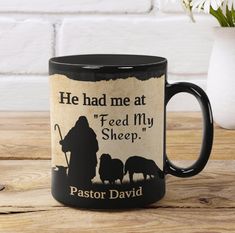 a black coffee mug with the words, he had me at feed my sheep