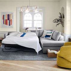 a living room filled with furniture and a large bed on top of a hard wood floor