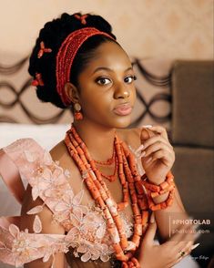 an african woman with beads on her head and necklaces around her neck, posing for the camera