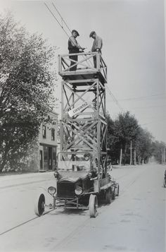 two men standing on the back of a truck