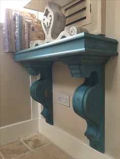 a blue shelf with some decorative items on top and a light switch in the corner