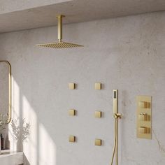 a bathroom with a sink, shower head and faucet in gold fixtures on the wall