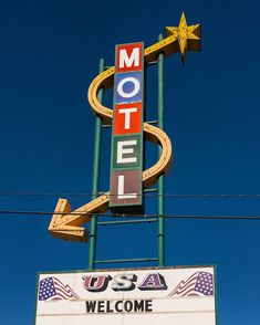 a motel sign with an american flag on it's side and the word usa welcome