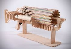 a wooden bench with magazines stacked on it's back and the seat folded down