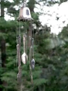 a wind chime hanging from the side of a tree in front of some trees