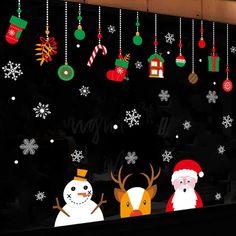 christmas window stickers with santa claus and snowman on the outside, hanging from strings