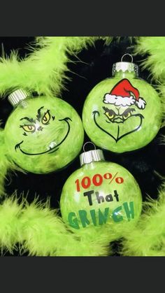 three green ornaments with faces painted on them and the words 100 % that griny