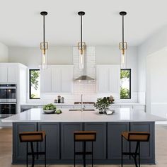 a large kitchen with an island and three bar stools