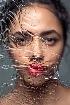 a woman's face is covered in plastic wrap and has red lipstick on her lips