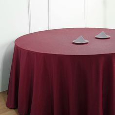 a red table with two white plates on it and a wall in the back ground