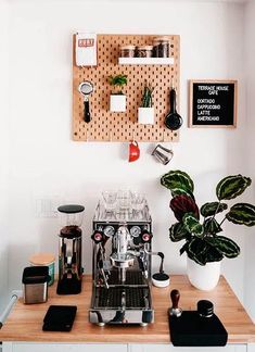 a coffee machine sitting on top of a wooden counter next to a potted plant