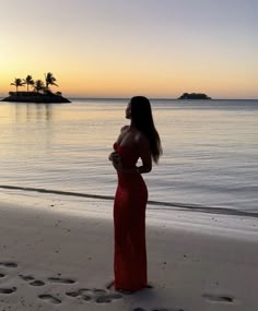 a woman standing on top of a beach next to the ocean