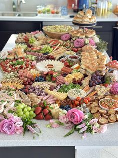 a table filled with lots of different types of food and flowers on top of it