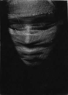 a black and white photo of a person's face covered in something with lines