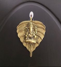 an elephant head is hanging from the side of a black door with a gold ornament on it