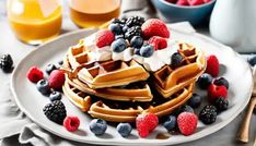 a white plate topped with waffles covered in fruit