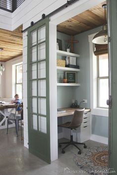 an open door leading to a kitchen and dining area with a table in the center