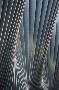 an abstract photograph of lines and shapes in grey tones, with blue sky behind them