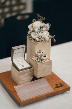 three wooden boxes with rings and flowers on them