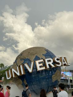 people are standing in front of the universal sign