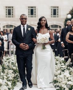 a bride and groom walking down the aisle