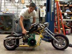 a man working on a small motorcycle in a garage with other tools and equipment behind him