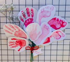 four handprints are placed on top of each other in front of a tiled wall