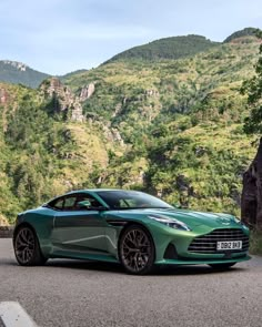 a green sports car parked in front of a mountain