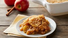 an apple cobbler on a plate with apples in the background