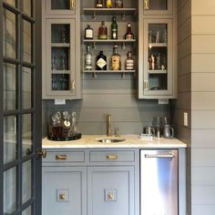 a kitchen with gray cabinets and white counter tops