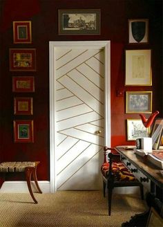 a room with red walls and pictures on the wall, including a door that has been painted white