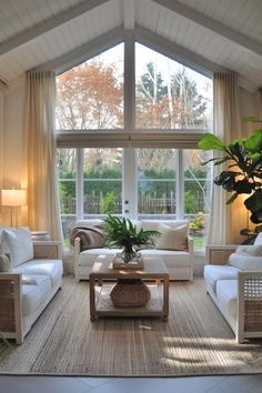 a living room with couches, chairs and a coffee table in front of a large window