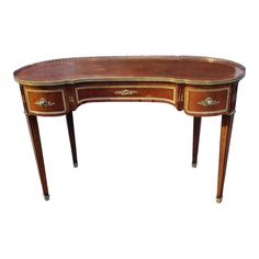 an antique desk with leather top and gold trimmings