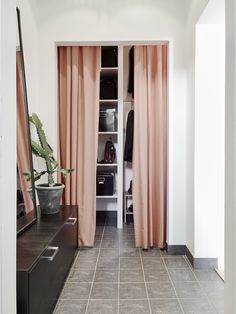 an open closet with pink drapes on the doors