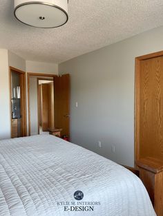 a bedroom with white bedding and wooden cabinets in it's corner, next to a closet