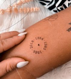 a woman's arm with a tattoo on it that reads, date and location