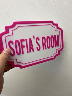 someone holding up a pink and white sign that says sofa's room