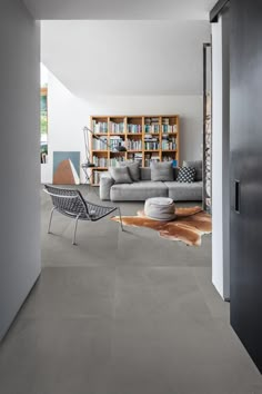 a living room filled with lots of furniture and bookshelves on the wall next to a doorway