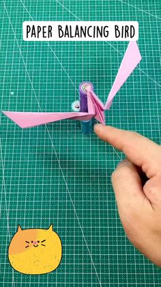 someone is making a paper bird that looks like a cat