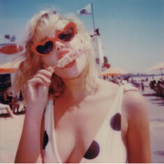 a woman in polka dot swimsuit with sunglasses on her face and tongue sticking out