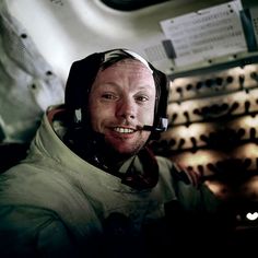 a man wearing an astronaut's helmet is smiling for the camera