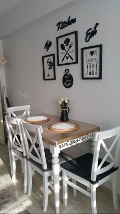 a dining room table and chairs with pictures on the wall above it, along with other decor