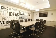 an empty conference room with black chairs and a large white boarder on the wall