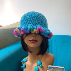 a mannequin wearing a blue hat with multicolored beads