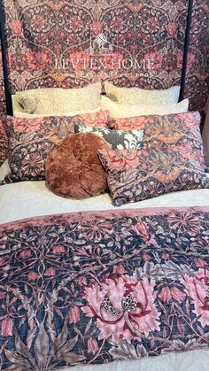 the bed is made with an intricately designed comforter and pillows on top of it