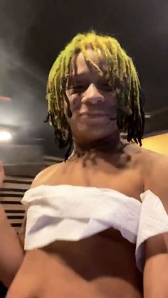 a man with yellow dreadlocks and no shirt